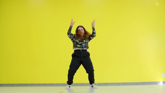 Girl dancing hip hop on the background of a yellow wall. Isolated.