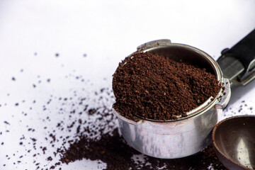 ground coffee in filter holder on white background