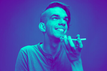 Recording voice. Close up portrait of caucasian man isolated on studio background. Modern and...