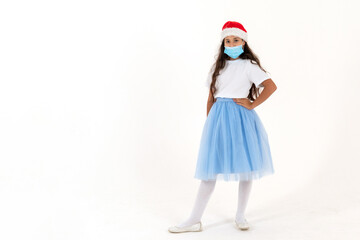 Adorable girl in a medical mask and santa claus hat on a white background. Snow Maiden.