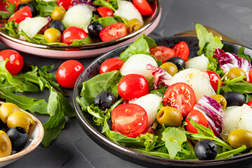  Fresh vegetable salad - tomatoes, lettuce, olives, arugula and olive oil. Close-up