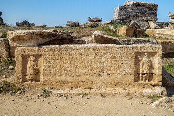 Burial plate from antique sarcophagus in Hierapolis, ancient city near Pamukkale, Turkey. There are ancient Greek writings on front side. Also there are bas-reliefs of 2 persons in Roman clothes
