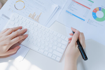 woman typing on wireless keyboard with business document and white isolated background