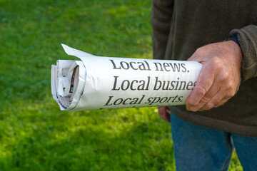 Rolled up copy of the local news newspaper.