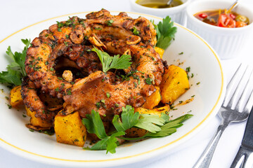 Grilled Octopus and potatoes over a white plate on a spanish restaurant