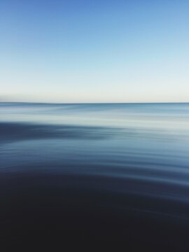 Tranquil movement shot of beautiful still blue ocean at dusk