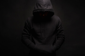 Man in Black Hood posing in dark studio