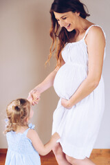 Fototapeta na wymiar Pregnant mother dancing with her daughter