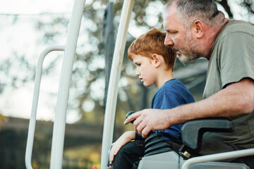 Close up of a father and son using a digger
