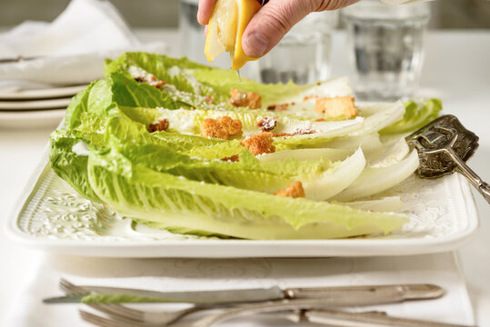 Squeezing Lemon on Caesar Salad