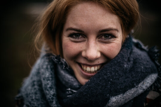 A smiling woman with red hair in a scarf