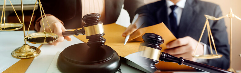 Business and lawyers discussing contract papers with brass scale on desk in office. Law, legal services, advice, justice and law concept picture with film grain effect