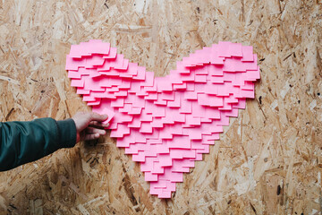 Person making heart of stickers