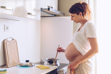 Pregnant cooking in her home.