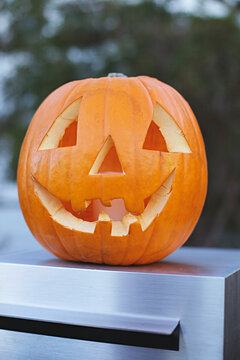 jack o lantern sitting on mailbox.