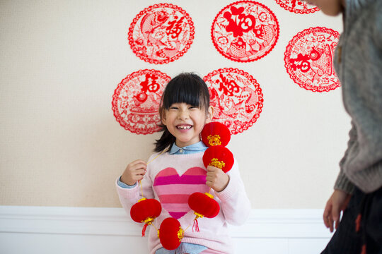 Happy little asian girl and boy decorate home with red lantern d