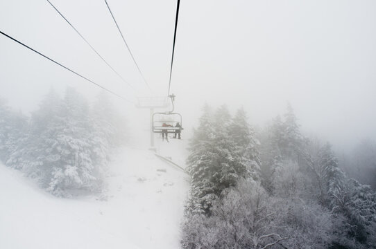 teens heading up a misty mountain on a chairlift