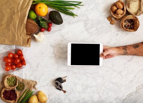 Man hands using device over marble table with healthy food