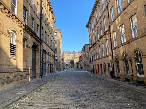Fototapeta Looking along, Cater Street, at former textile buildings, built with Yorkshire stone in, Little Germany, Bradford, UK
