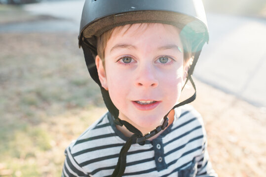 child with bike helmet looking at camera