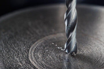 metal drill bit make holes in steel billet on industrial drilling machine. Metal work industry....