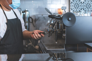 Blurred soft images of Coffee maker or barista wearing surgical mask, Using Automatic coffee machines are working by distilling concentrated drink, to people and health concept.