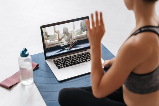 Close Up Of Young Fit Woman Coach In Sportswear Conducting Online Fitness Training Or Virtual Yoga Class On A Video Conference With Laptop. Home Workout Training. Health Practice And Wellness Concept 