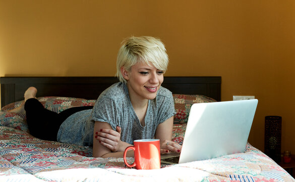 beautiful smiling girl with pixie haircut surfing the Internet