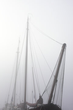 Old boat in the harbour on a foggy morning