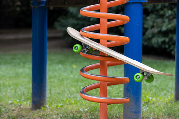 orange playground for children with wooden skateboard with green wheels