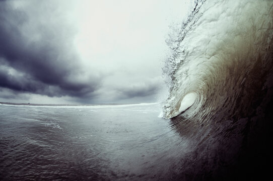 breaking wave with clouds in the backdrop
