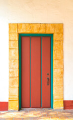 vintage red wooden door with a sandstone brick border