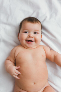 Chubby Infant Baby Nude on Bed Sheet