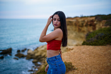 Chica caminando por ruta de playa camino de madera y vegetacion junto a un acantilado en cadiz el...