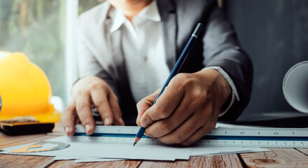 Two colleagues discussing data working and tablet, laptop with on on architectural project at construction site at desk in office