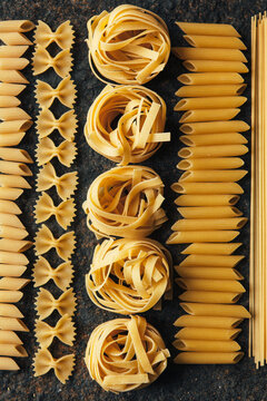 Different kind of pasta on dark background