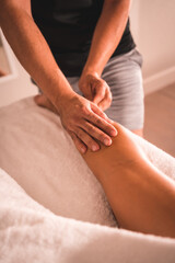 Physiotherapist's massage on the back of the left leg of a young woman lying on the table. Physio, osteopathy, relaxing massage, motion video of treatment on the back