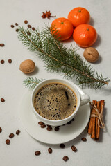 White Cup of hot coffee drink and tangerines on a light aged background. Winter composition. Holiday concept, selective focus.