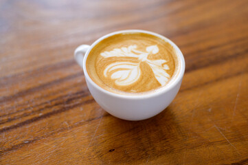 top view of cup of hot latte art on wooden table background