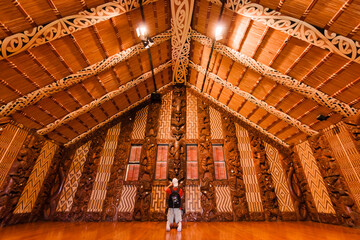 Tourist photographing interior of Maori meeting house in Waitangi, New Zealand - obrazy, fototapety, plakaty