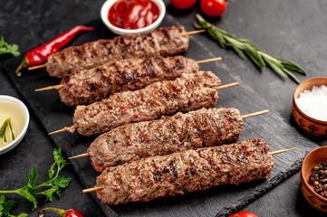 grilled Lula kebab on skewers with spices on a stone background

