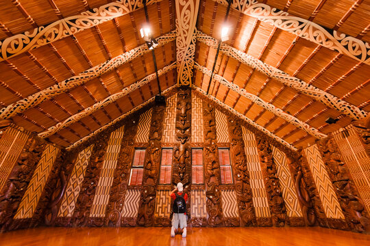 Tourist photographing interior of Maori meeting house in Waitangi, New Zealand