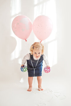 Birthday girl with two pink balloons