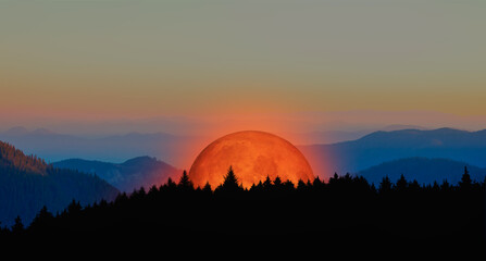 Fantasy landscape - (Lunar eclipse) Full moon rising through blue mountains 