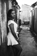 Chica joven con falda en una calle estrecha de un barrio pobre de favela en rio de janeiro brasil con muchos colores en sus casas casseria de ossio san fernando sur de españa