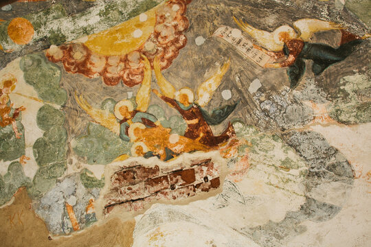 Aged wall-painting with saints and angels