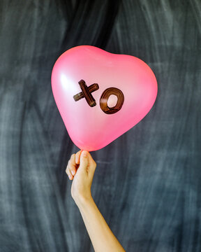 Hand holding XO balloon