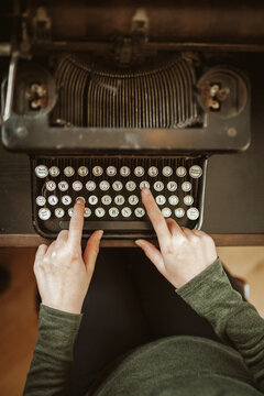 Woman typing on an old typewriter.