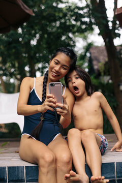 Mom taking selfie with son at pool