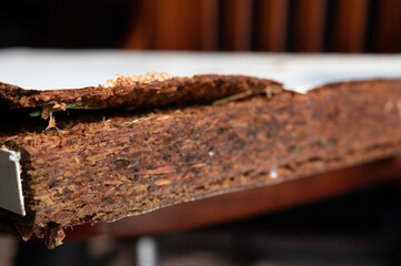 Selective focus on edge of water damaged swelled laminated plywood